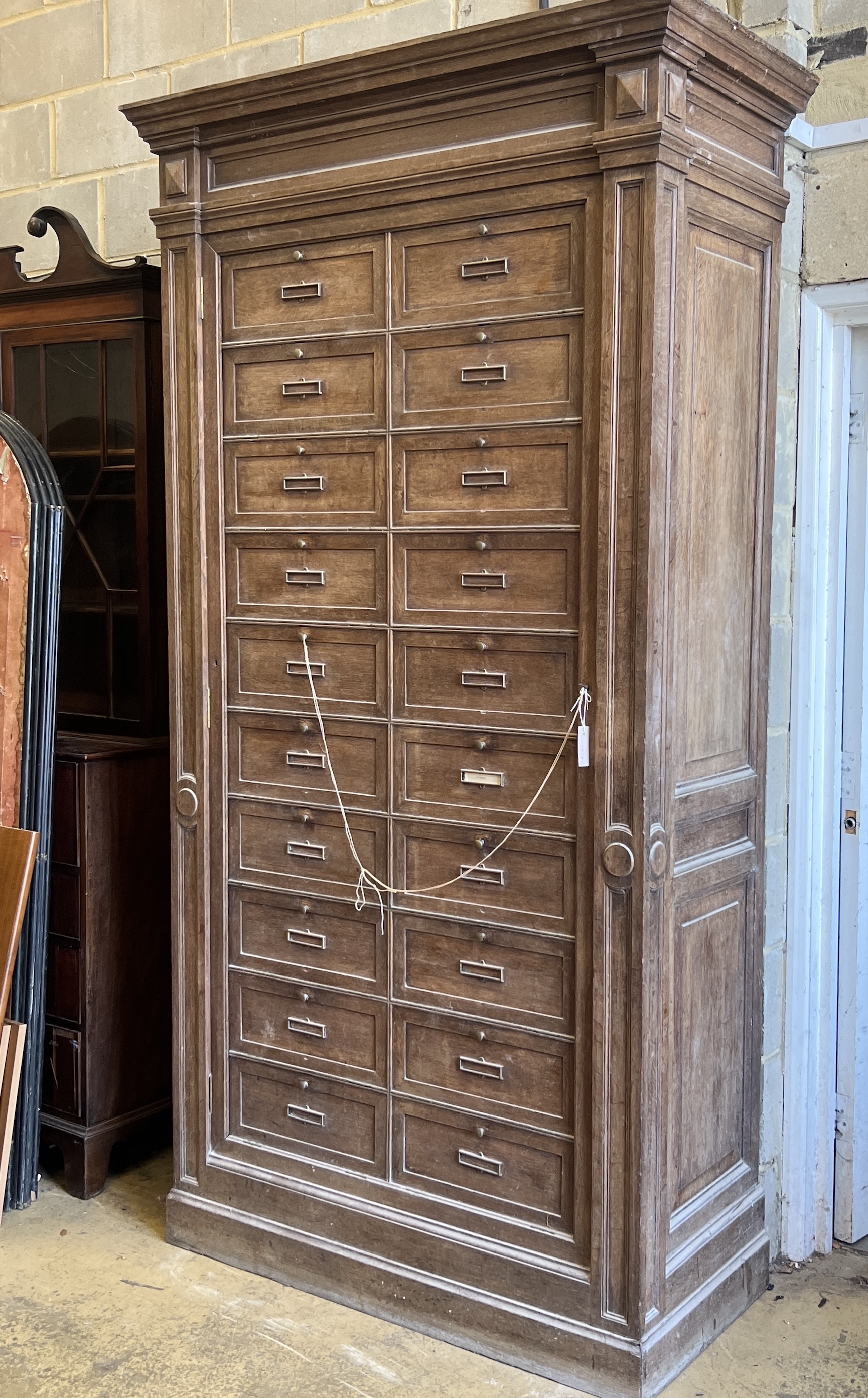 An early 20th century French oak notaries cabinet with 20 fall front compartments, width 125cm, depth 60cm, height 240cm